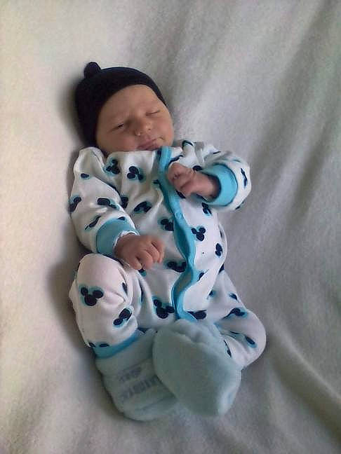 Jonas a rejoint le concours — aidez-le/la à gagner de superbes lots ! baby, baby_toddler_clothing, beanie, child, comfort, electric_blue, foot, fur, headwear, linens, pattern, person, room, sitting, sleeve, textile, toddler, toy