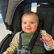 Pablo participe au concours pour gagner de l'argent avec cette photo : baby, child, infant, stroller, car_seat, harness, smile, blue_eyes, chubby_cheeks, overalls, striped_shirt, hand, seat_belt, portrait, close_up, happy, bright_eyes, skin, indoor, fabric