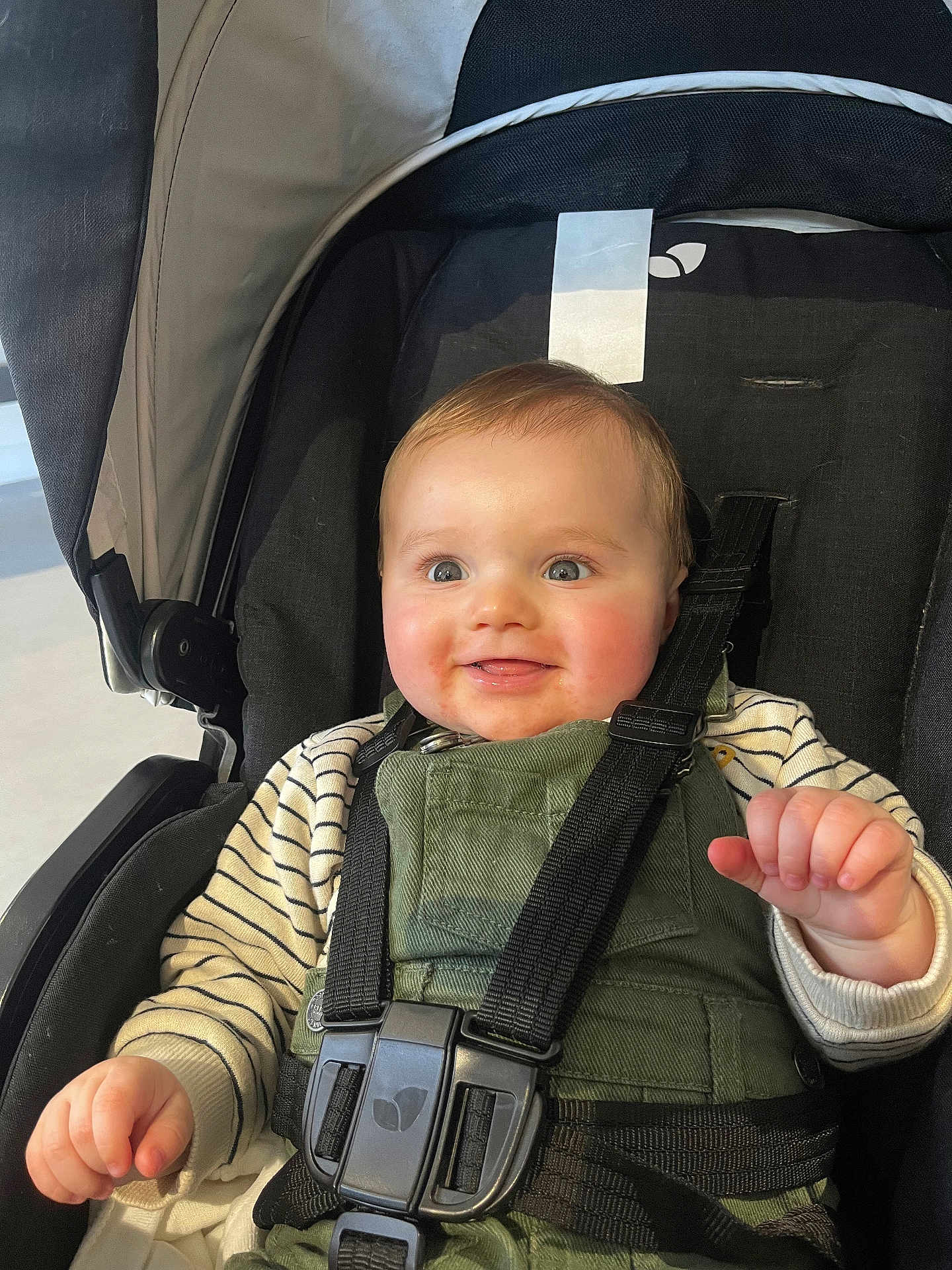 Pablo participe au concours pour gagner de l'argent avec cette photo : baby, child, infant, stroller, car_seat, harness, smile, blue_eyes, chubby_cheeks, overalls, striped_shirt, hand, seat_belt, portrait, close_up, happy, bright_eyes, skin, indoor, fabric