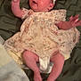 Amelia joined the competition — help win amazing prizes! baby, infant, child, flower_headband, floral_dress, blanket, indoor, cute, expression, motion, legs, arms, face, head, skin, person, soft, cozy, playful, lying_down