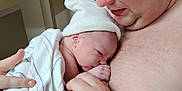 Jerry is registered to the contest to win money with this photo: baby, newborn, adult, holding, blanket, hat, skin, face, hand, closeup, indoors, person, love, care, tenderness, family, portrait, gentle, warmth, bond