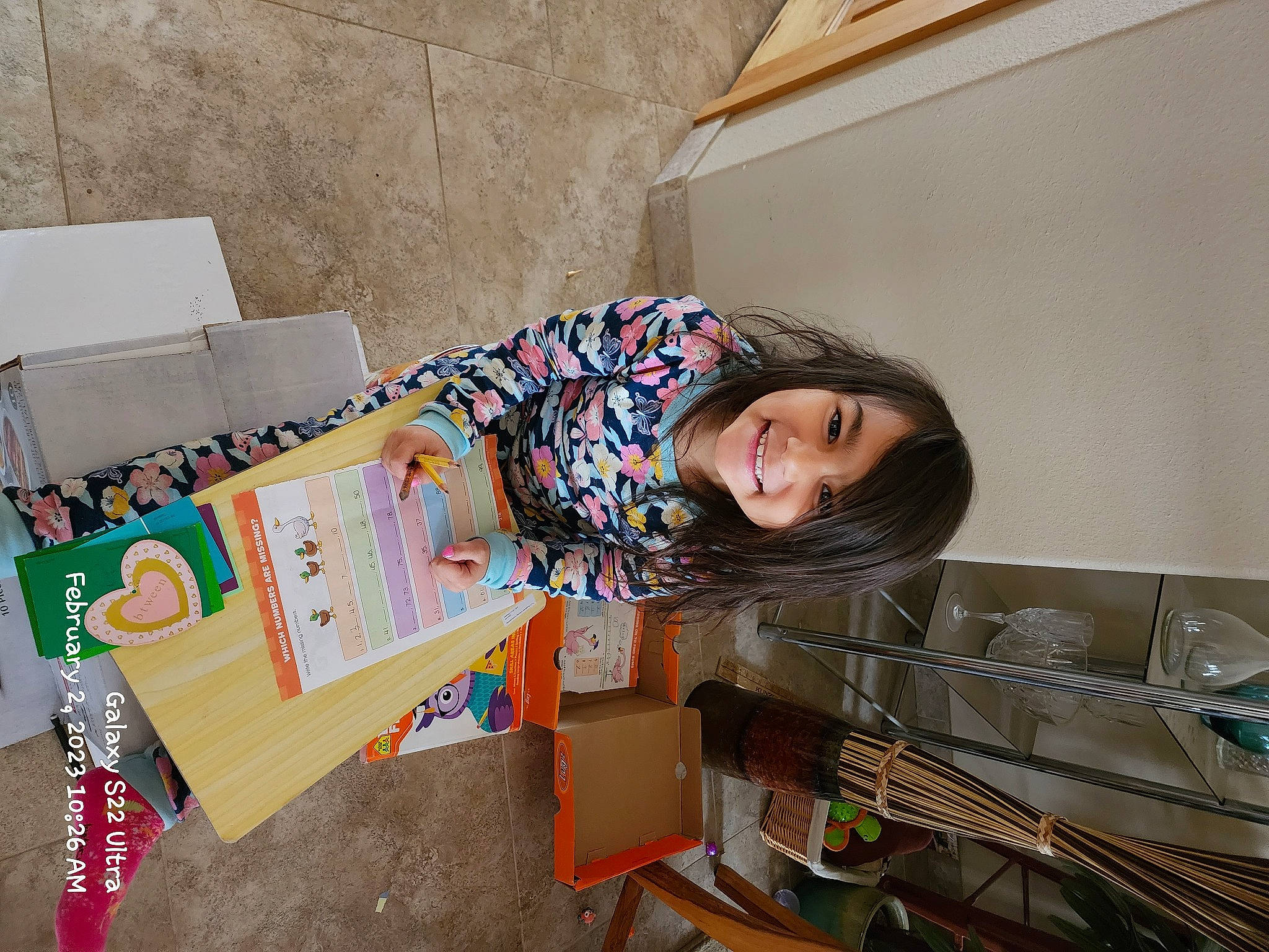 Chassy is registered to the contest to win money with this photo: box, cardboard, carton, child, flooring, fun, happy, joy, leisure, packing_materials, paper_product, person, room, shipping_box, sitting, smile, toddler, travel, wood