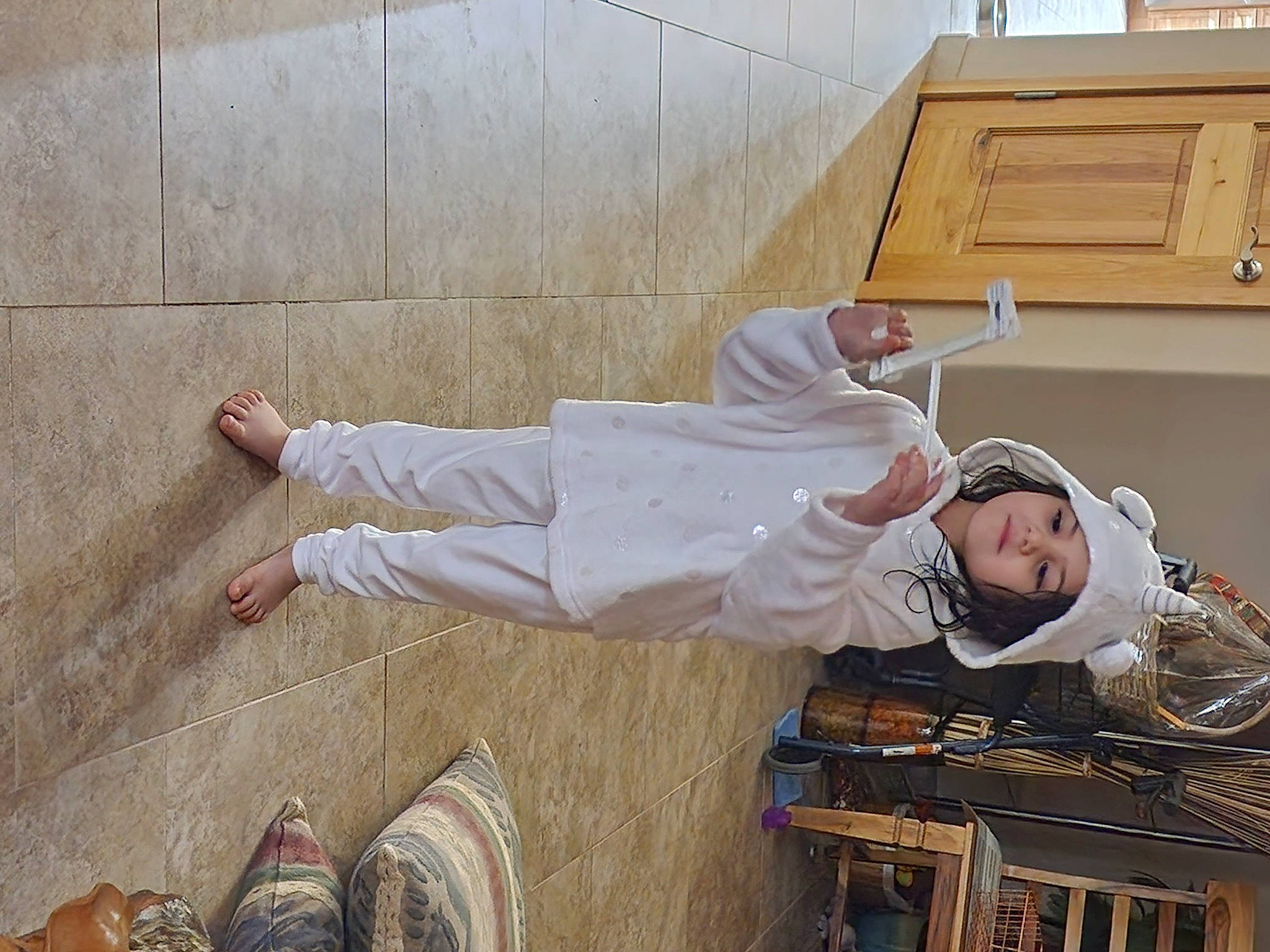 Lexi joined the competition — help win amazing prizes! child, flooring, foot, footwear, hat, headwear, helmet, human_leg, person, sitting, sneakers, walking_shoe, wood