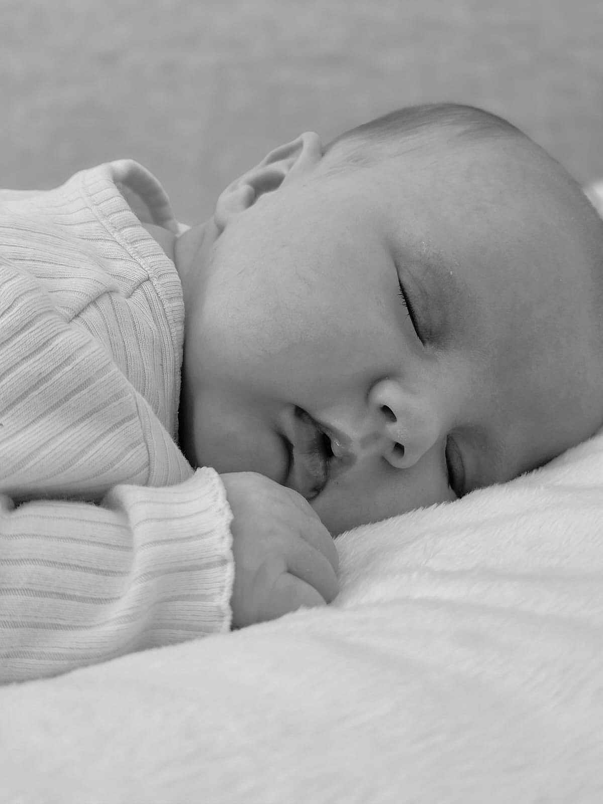 Amelia joined the competition — help win amazing prizes! baby, sleeping, infant, close_up, black_and_white, soft_texture, peaceful, face, hand, clothing, blanket, newborn, portrait, resting, cute, young_child, skin, expression, calm, comfort