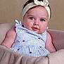 baby, infant, headband, dress, striped_clothing, strawberry_pattern, blanket, soft_texture, cute, portrait, child, face, cheeks, eyes, sitting, indoor, comfortable, clothing, young_child, adorable