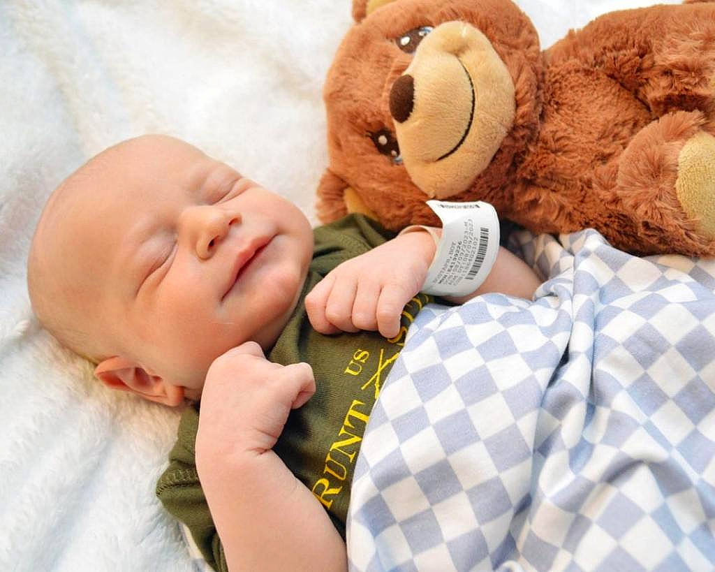 Chase joined the competition — help win amazing prizes! baby, baby_sleeping, baby_toddler_clothing, bed, child, comfort, gesture, happy, head, linens, mammal, pattern, person, plaid, plush, skin, stuffed_toy, teddy_bear, textile, toddler