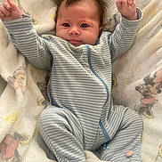 Avyanna is registered to the contest to win money with this photo: baby, infant, onesie, striped_clothing, blanket, soft_toy, cute, smiling, happy, lying_down, raised_arms, spiky_hair, indoor, child, face, footed_pajamas, pink_details, cozy, comfort, portrait
