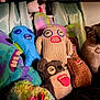 cat, plush_toys, stuffed_animals, colorful, teeth, knitted, furry, indoor, fabric, creepy, quirky, sitting, collection, face, eyes, toy, animal, cute, dark, shadow