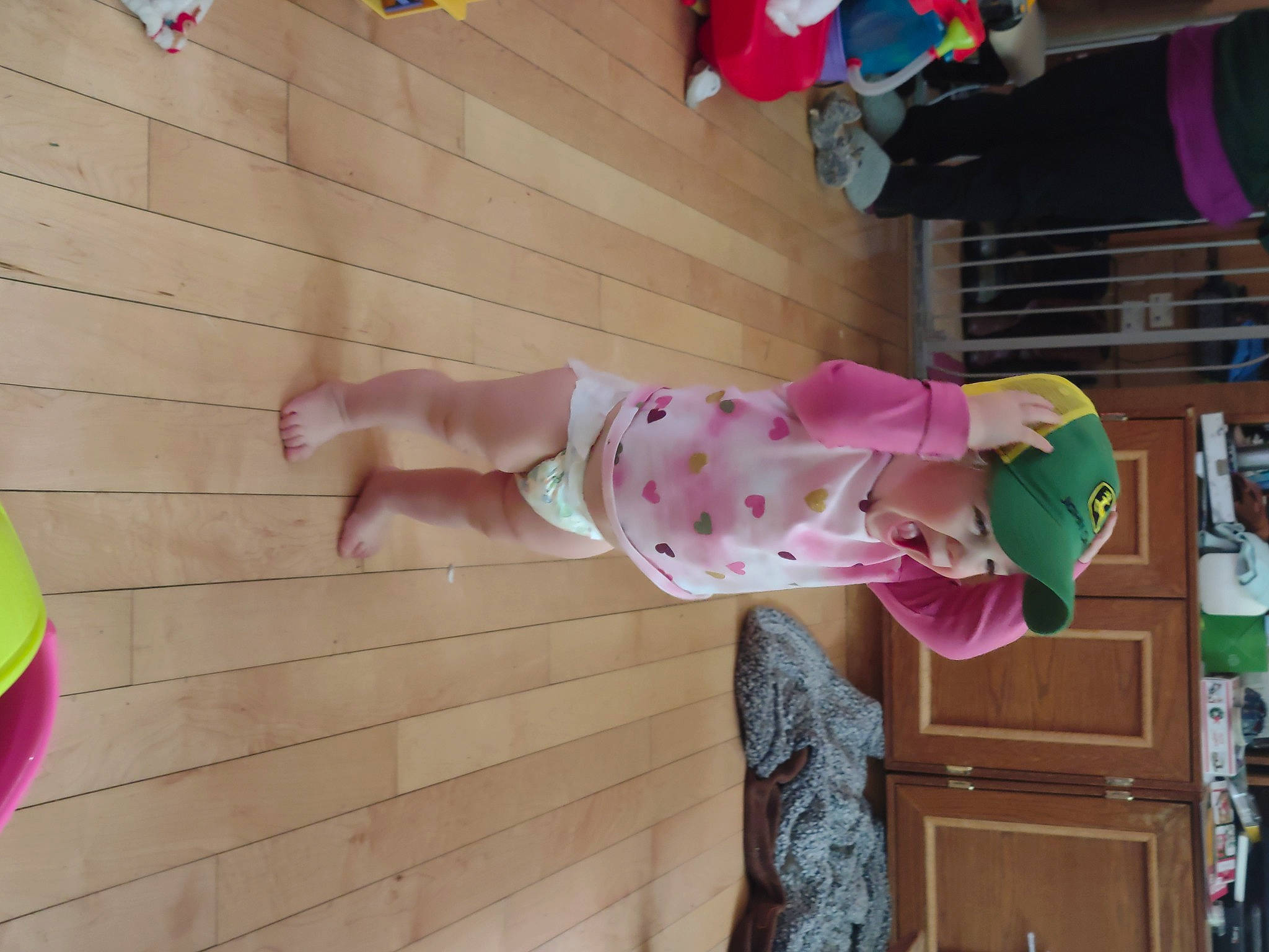 Karlie is registered to the contest to win money with this photo: baby, baby_products, baby_toddler_clothing, child, door, foot, fun, happy, headwear, human_leg, leisure, magenta, pattern, person, pink, play, room, standing, textile, thumb