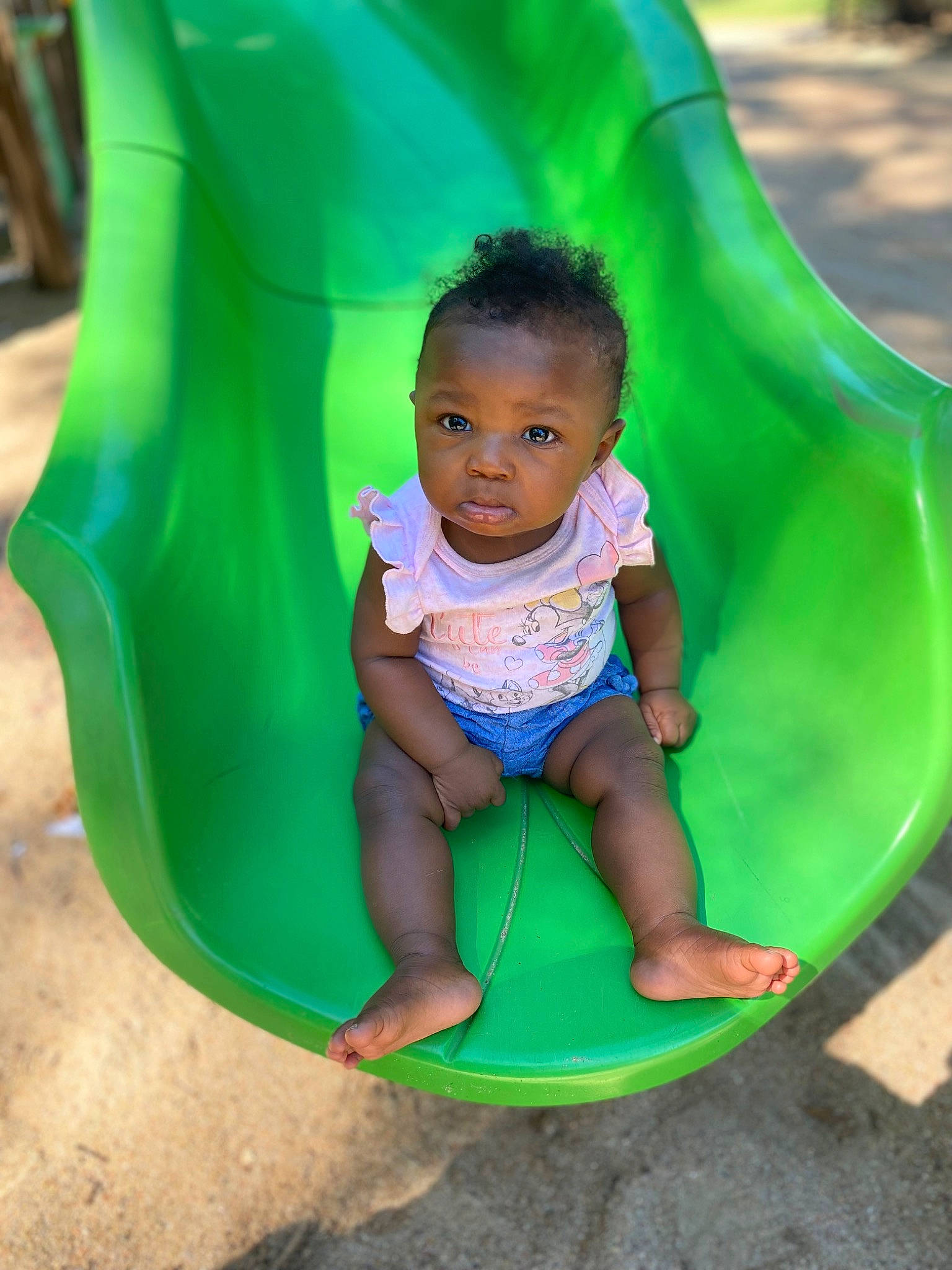 Raniya is registered to the contest to win money with this photo: aqua, baby_toddler_clothing, chute, eye, facial_expression, fun, grass, green, happy, head, leaf, leisure, organ, outdoor_play_equipment, person, pink, playground, playground_slide, product, recreation