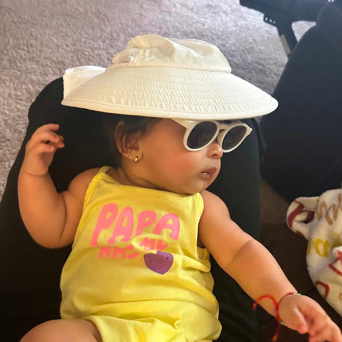 Ysabell is registered to the contest to win money with this photo: accessories, baby, bodypart, bracelet, cap, clothing, couch, face, furniture, glasses, hat, head, jewelry, person, photography, portrait, sitting, sunglasses, sunhat, t_shirt