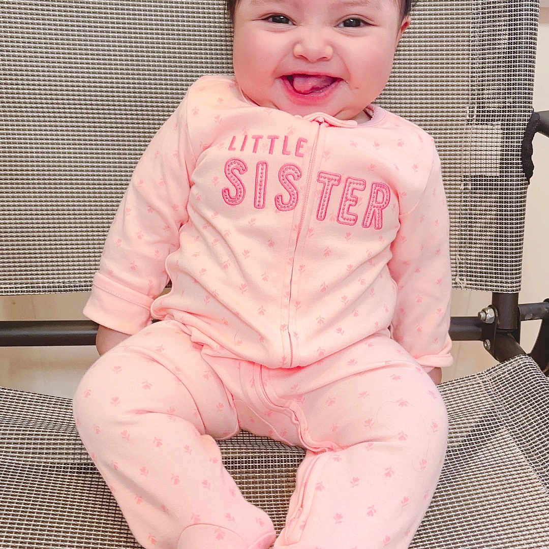 America joined the competition — help win amazing prizes! baby, baby_girl, child, clothing, cute, expression, face, footed_pajamas, hair, happy, indoor, infant, joyful, mesh_chair, person, pink_onesie, portrait, sitting, smiling, young_child