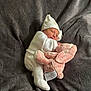 newborn, baby, sleeping, plush_toy, pink_bunny, white_clothing, hat, blanket, cozy, soft, infant, cute, resting, indoors, child, toddler, sleep, comfort, warm, snuggle