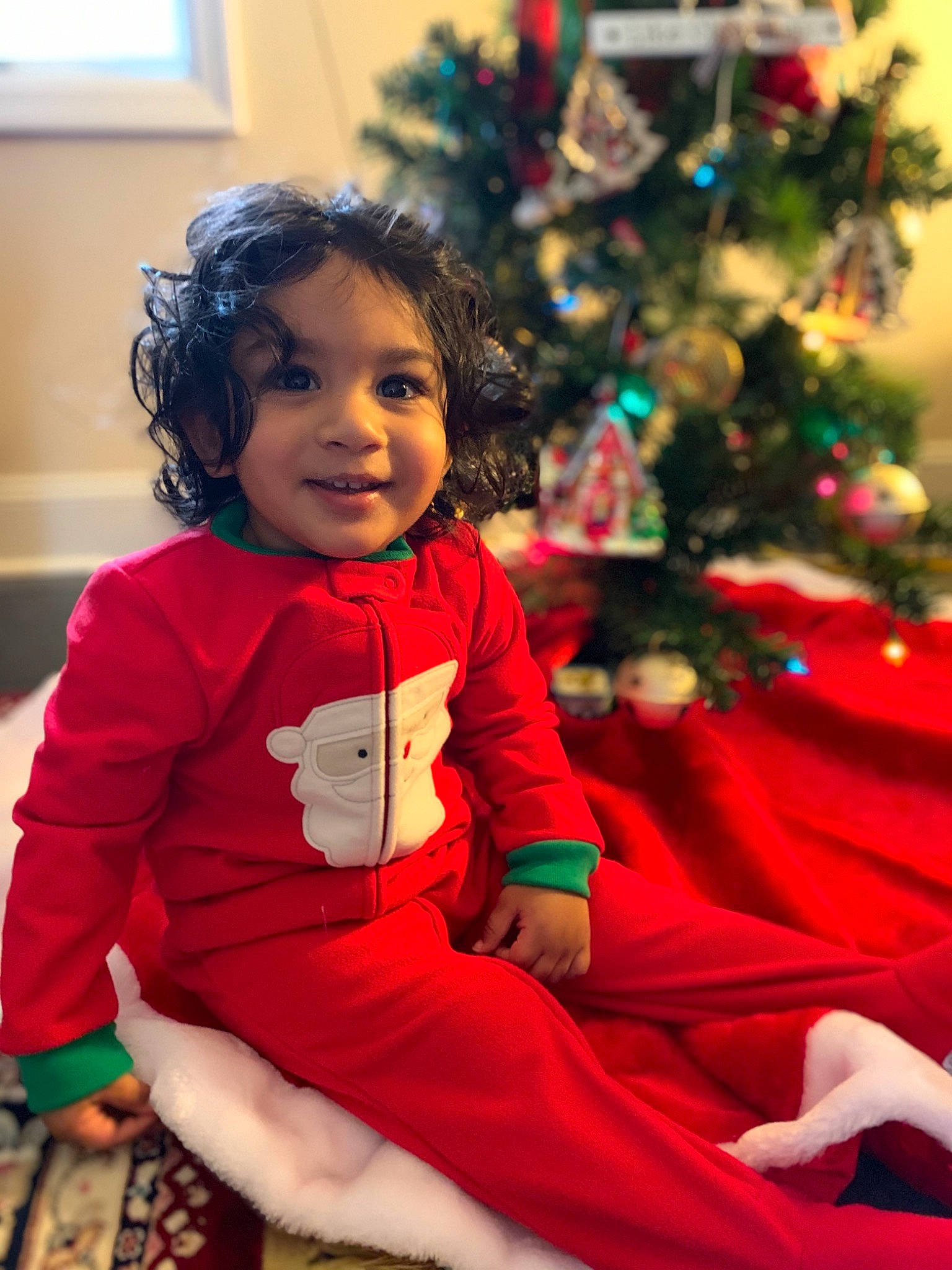 Riaan is registered to the contest to win money with this photo: baby_toddler_clothing, christmas, christmas_decoration, christmas_ornament, christmas_tree, event, evergreen, eye, facial_expression, happy, holiday, human_body, joy, ornament, person, red, skin, sleeve, smile, standing