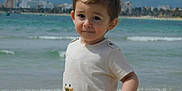 Nathan a rejoint le concours — aidez-le/la à gagner de superbes lots ! beach, buildings, casual_clothing, child, cityscape, daytime, nature, ocean, outdoor, portrait, sand, short_sleeve_shirt, sky, smile, summer, toddler, vacation, water, waves, young_child
