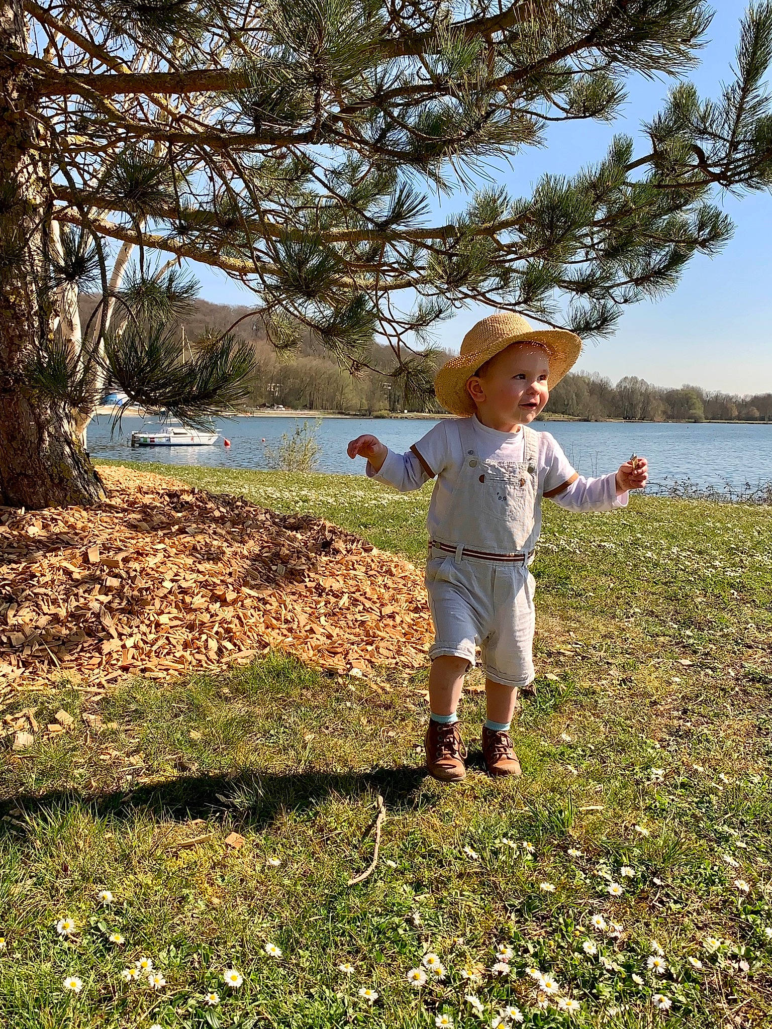 Tim participe au concours pour gagner de l'argent avec cette photo : baby, grass, grassland, happy, hat, headwear, lake, landscape, leaf, leisure, meadow, natural_landscape, people_in_nature, person, plant, recreation, sky, sun_hat, sunlight, toddler