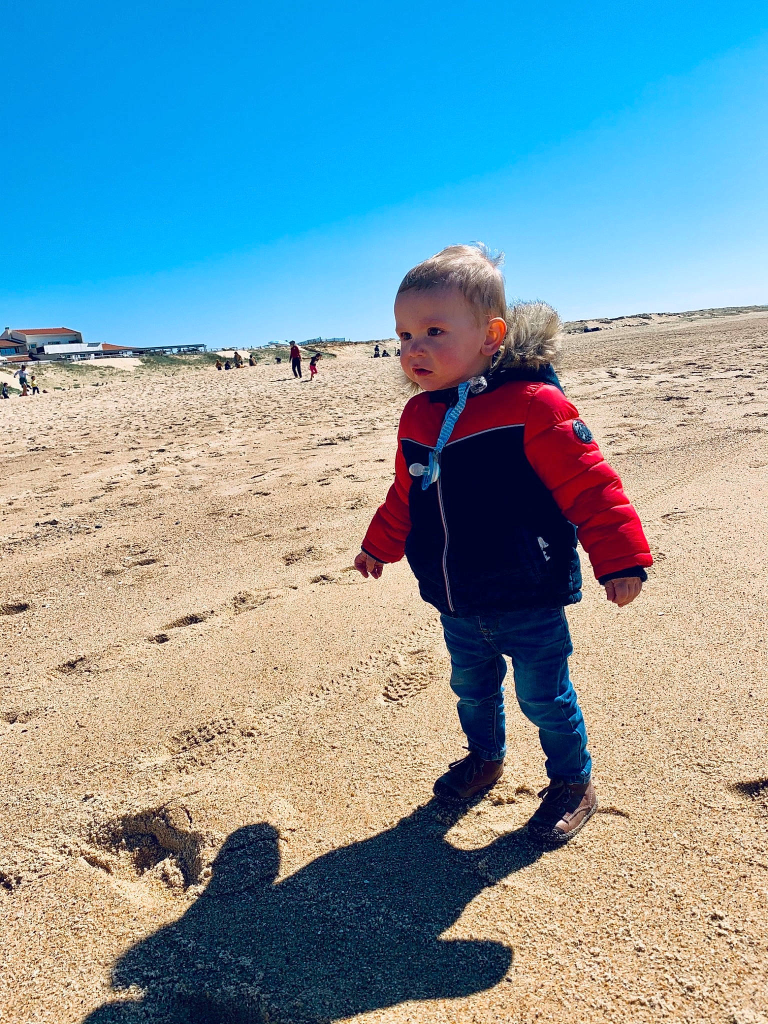 Tim participe au concours pour gagner de l'argent avec cette photo : azure, body_of_water, child, ecoregion, electric_blue, fun, gesture, happy, horizon, landscape, leisure, people_in_nature, person, sand, shadow, shore, sky, soil, tints_and_shades, toddler