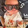 Leo joined the competition — help win amazing prizes! baby, infant, sunglasses, onesie, crab_pattern, blanket, person, clothing, cute, sleeping, newborn, holding, casual, comfort, closeup, indoor, relaxed, adorable, face, head