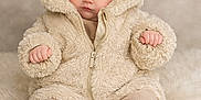 Mavis is registered to the contest to win money with this photo: baby, infant, child, fluffy_jacket, bear_ears, hood, boots, soft_rug, blue_eyes, cute, warm_clothing, sitting, portrait, indoor, cozy, fuzzy_texture, small_hands, expression, neutral_face, young