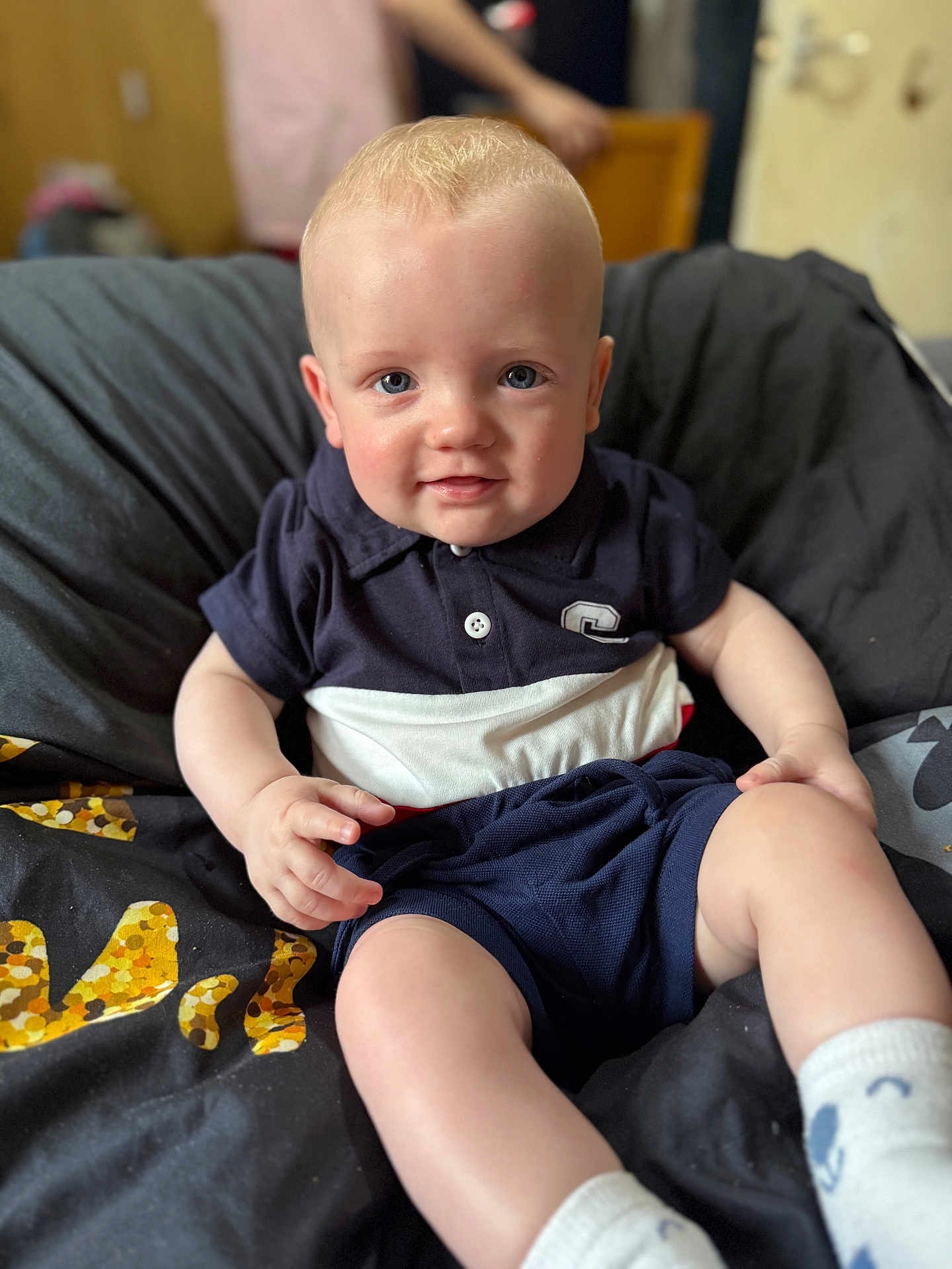 Kayden-Lee is registered to the contest to win money with this photo: baby, child, infant, smile, blue_eyes, shorts, socks, polo_shirt, cushion, indoor, portrait, cute, sitting, blond_hair, young, person, comfortable, clothing, skin, happy