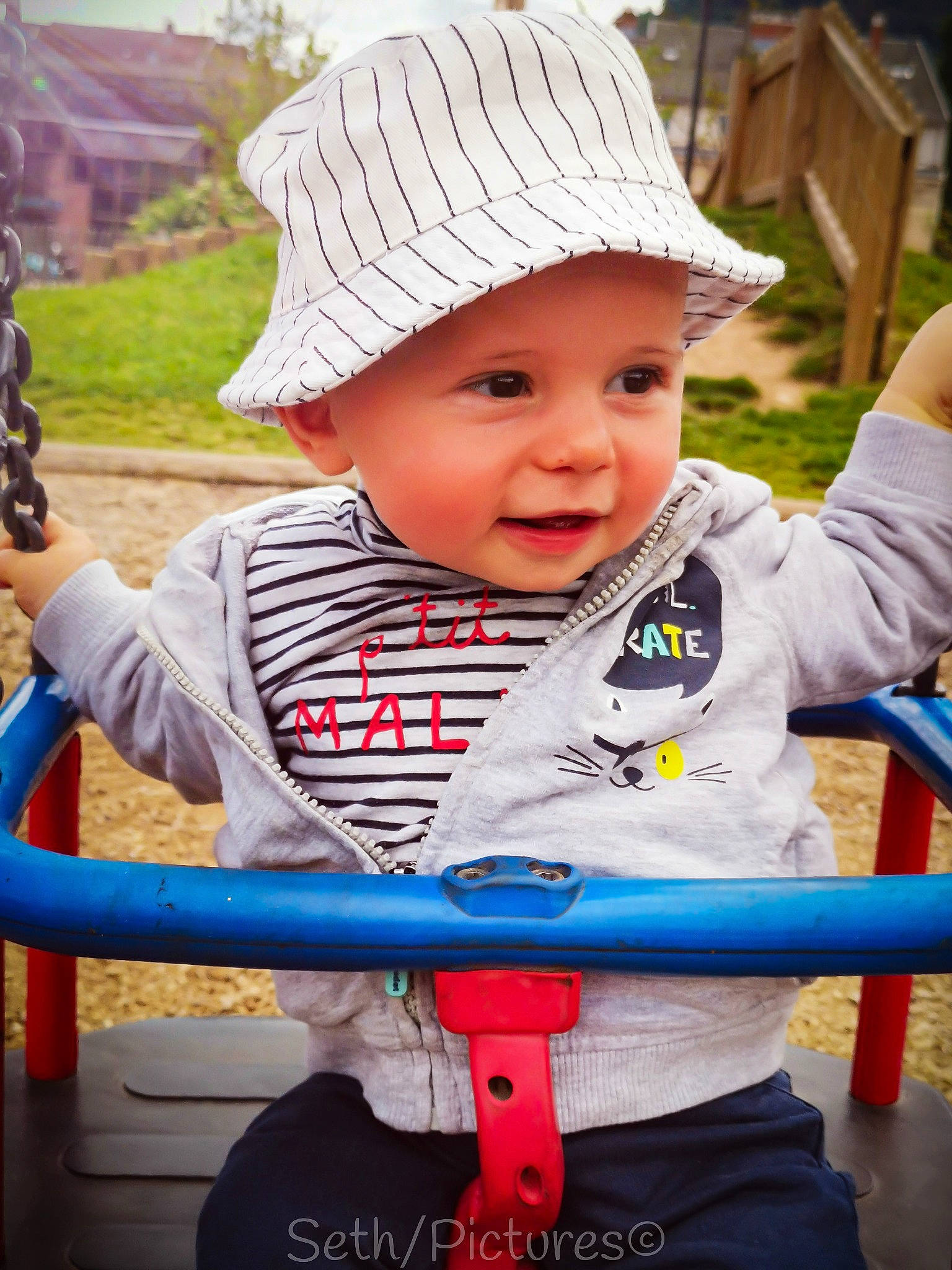 Elijah participe au concours pour gagner de l'argent avec cette photo : baby, baby_toddler_clothing, beauty, blue, cap, child, chin, city, fun, grass, happy, headwear, leisure, outdoor_play_equipment, person, product, public_space, recreation, skin, smile