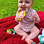 Hailey joined the competition — help win amazing prizes! baby, blanket, chewing, child, closeup, colorful, cute, grass, greenery, happy, infant, outdoor, person, playful, red_blanket, sitting, soft_skin, summer, sunny, toy