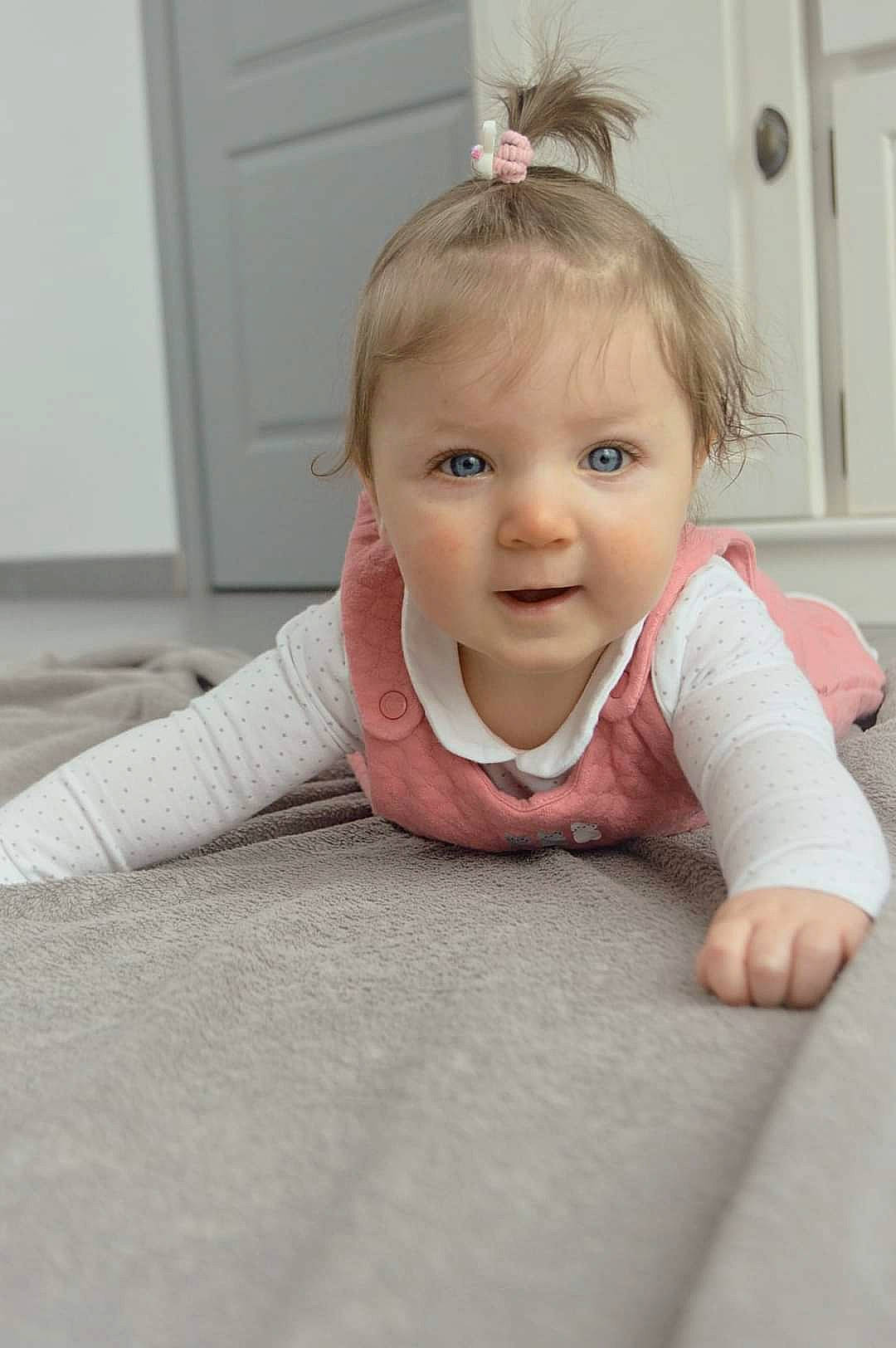 Eliana a rejoint le concours — aidez-le/la à gagner de superbes lots ! arm, baby, baby_crawling, baby_toddler_clothing, cheek, door, eyebrow, floor, flooring, gesture, happy, headgear, iris, neck, nose, person, skin, sleeve, smile, toddler