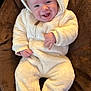 Jude is registered to the contest to win money with this photo: baby, infant, smiling, onesie, white_clothing, hood, soft_texture, blanket, brown, cute, happy, portrait, child, cozy, warm, indoors, person, face, newborn, cuteness