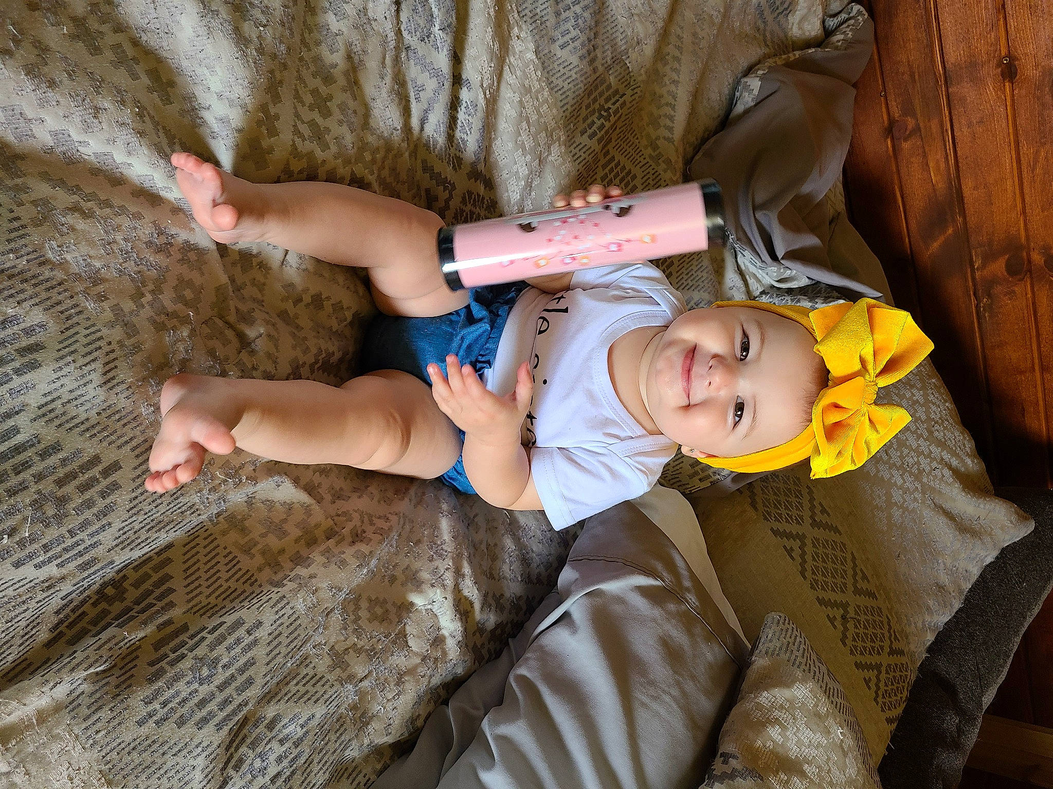 Maisie is registered to the contest to win money with this photo: baby, baby_toddler_clothing, child, comfort, dress, facial_expression, fun, grass, happy, hat, human_body, joy, lap, leg, person, skin, smile, textile, thigh, toddler