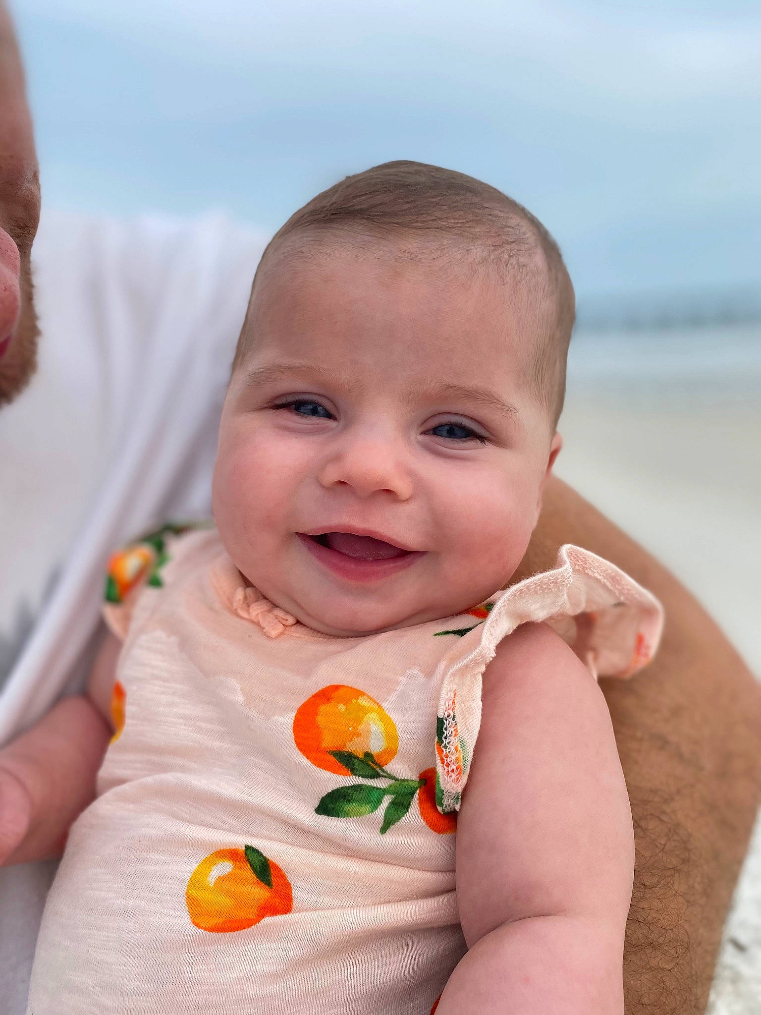 Mattie is registered to the contest to win money with this photo: baby, baby_toddler_clothing, cheek, dress, finger, gesture, hand, happy, iris, joy, lip, mouth, nose, people_in_nature, person, plant, skin, sky, sleeve, smile