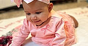 Andi joined the competition — help win amazing prizes! baby, infant, pink_outfit, headband, bow, blanket, floral_pattern, crib, floor, crawling, child, cute, smiling, indoors, soft_lighting, portrait, toddler, happy, person, clothing