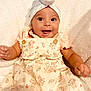 baby, child, smiling, infant, floral_dress, headwear, white_turban, blanket, happy, cute, portrait, skin, person, indoors, baby_girl, clothing, soft_texture, button, hands, lying_down