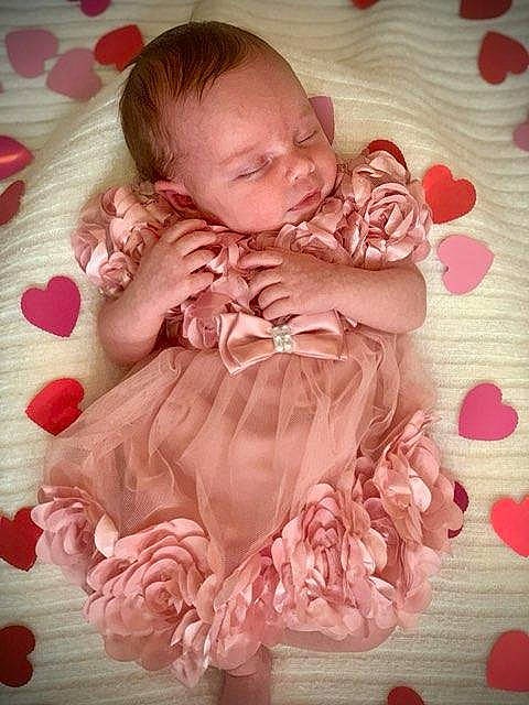 Francesca is registered to the contest to win money with this photo: baby, baby_products, baby_toddler_clothing, cheek, child, comfort, dress, face, flooring, hand, happy, head, iris, linens, magenta, pattern, person, pink, sitting, skin