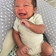 Theo joined the competition — help win amazing prizes! baby, infant, smiling, happy, onesie, socks, cushion, polka_dot, face, hand, foot, skin, person, newborn, cute, indoors, portrait, child, seated, cozy
