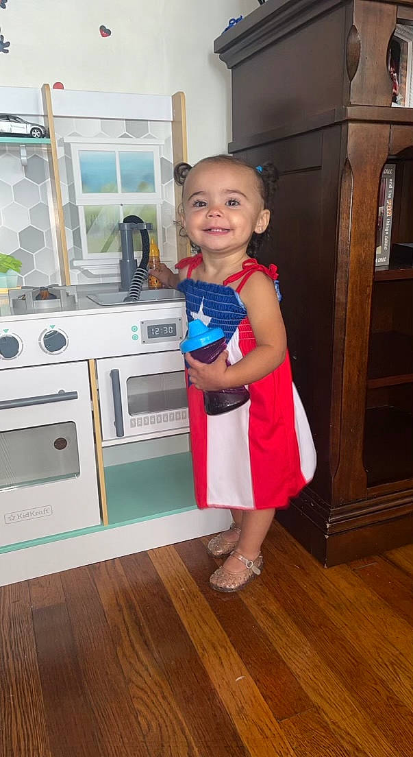 Myliana joined the competition — help win amazing prizes! cabinetry, child, cooking, cooktop, floor, flooring, gas, gas_stove, hardwood, home_appliance, joy, kitchen, kitchen_appliance, kitchen_stove, major_appliance, person, shoulder, smile, standing, toddler