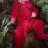 baby, infant, child, santa_hat, christmas, christmas_tree, red_outfit, festive, holiday, portrait, face, eyes, smiling, sitting, lying_down, greenery, tree_branches, ornaments, indoor, photography