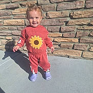 Harmony joined the competition — help win amazing prizes! toddler, child, smiling, standing, outdoor, sunlight, sunflower, sweatshirt, tracksuit, red_clothing, purple_shoes, clogs, brick_wall, stone_wall, patio, shadow, portrait, full_body, happy, fashion