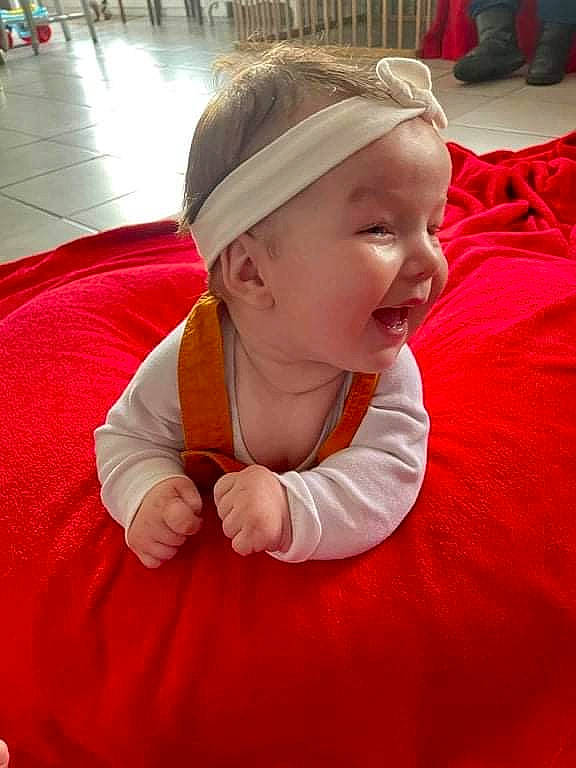 Maëssane participe au concours pour gagner de l'argent avec cette photo : baby, baby_toddler_clothing, cap, child, event, facial_expression, fashion_accessory, flooring, fun, grass, happy, laugh, leisure, magenta, person, pink, play, recreation, sitting, smile