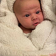 Lilli is registered to the contest to win money with this photo: baby, newborn, blanket, swaddled, car_seat, infant, face, eyes, soft_texture, clothing, fluffy, pastel_colors, pattern, person, child, cute, indoors, closeup, head, portrait