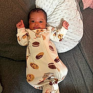 Ka'Tori joined the competition — help win amazing prizes! baby, infant, onesie, cookie_pattern, pillow, couch, sofa, fabric, face, person, sleepwear, baby_clothing, indoors, cute, newborn, resting, raised_hands, texture, soft, comfort