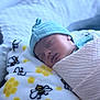 newborn, baby, sleeping, swaddle, hat, blanket, bee_pattern, honeycomb_pattern, soft_texture, cozy, peaceful, infant, cute, resting, indoor, closeup, portrait, child, headwear, fabric