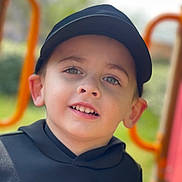 Tyago participe au concours pour gagner de l'argent avec cette photo : child, boy, face, smile, cap, hoodie, outdoor, playground, portrait, young, happy, casual_clothing, daylight, headwear, person, childhood, expression, greenery, blurred_background, cute