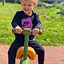 Tonio participe au concours pour gagner de l'argent avec cette photo : child, smiling, playground, seesaw, outdoor, sunny, greenery, curly_hair, happy, casual_clothing, sneakers, black_pants, black_sweatshirt, daylight, toy, recreation, fun, youth, person, holding
