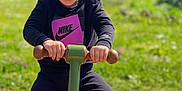 Tonio a rejoint le concours — aidez-le/la à gagner de superbes lots ! child, toddler, smiling, playground, rocker, outdoor, greenery, sunlight, nike, black_clothing, sneakers, happy, playing, daytime, grass, toy, fun, young_child, casual, active