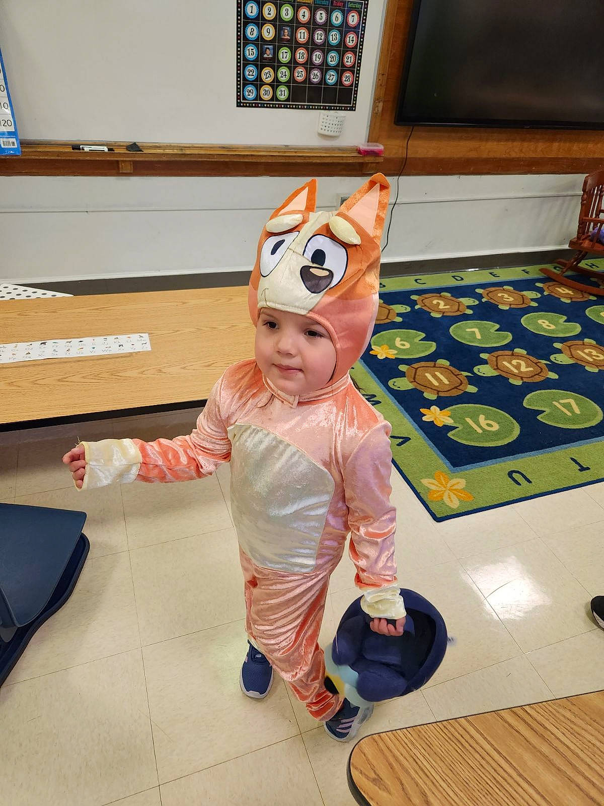 Elianna is registered to the contest to win money with this photo: animation, art, chair, child, costume, fictional_character, floor, flooring, fun, fur, hardwood, headwear, mascot, person, personal_protective_equipment, play, room, smile, stuffed_toy, toddler