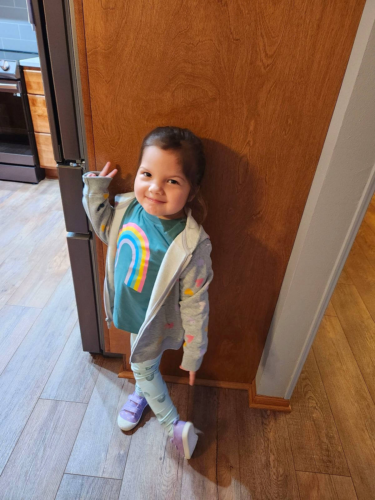 Elianna joined the competition — help win amazing prizes! baby_toddler_clothing, child, door, facial_expression, floor, flooring, fun, happy, hardwood, head, joy, laminate_flooring, person, skin, smile, sneakers, standing, toddler, varnish, wood