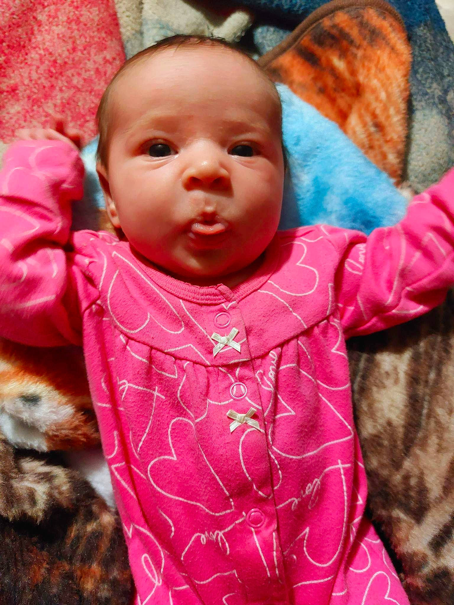 Lilliana is registered to the contest to win money with this photo: baby, baby_toddler_clothing, cheek, child, eye, face, facial_expression, happy, head, iris, lip, mouth, nose, organ, person, pink, red, skin, sleeve, textile