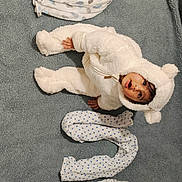 Gatha a rejoint le concours — aidez-le/la à gagner de superbes lots ! baby, bear_costume, blanket, child, cozy, creative_arrangement, curious, cute, expression, fluffy_suit, gray_background, indoors, infant, lying_down, number, patterned_blankets, portrait, rolled_blankets, soft_texture, warm_clothing