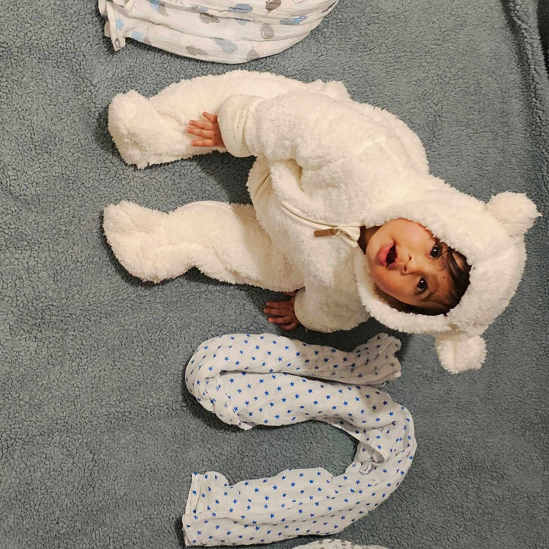 Gatha a rejoint le concours — aidez-le/la à gagner de superbes lots ! baby, bear_costume, blanket, child, cozy, creative_arrangement, curious, cute, expression, fluffy_suit, gray_background, indoors, infant, lying_down, number, patterned_blankets, portrait, rolled_blankets, soft_texture, warm_clothing