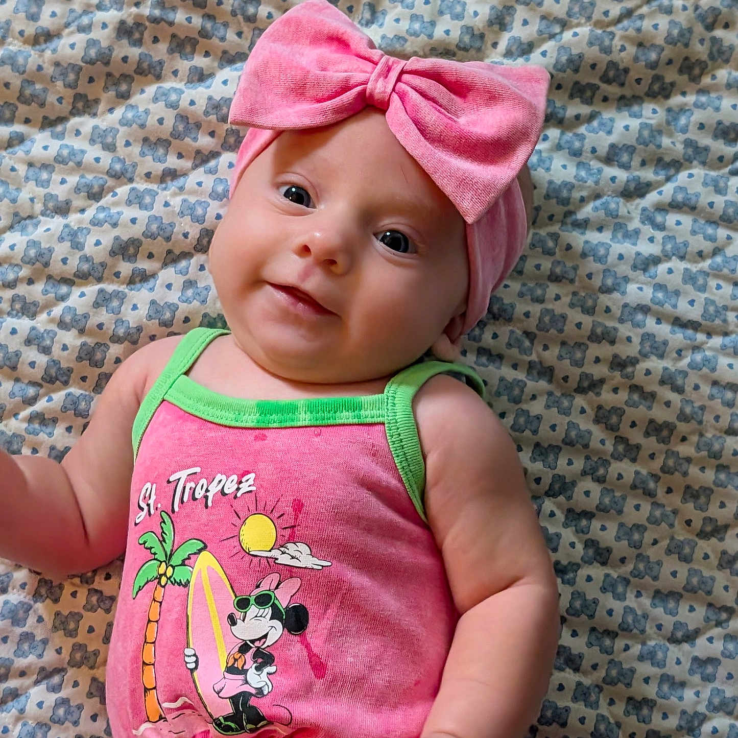 Asher joined the competition — help win amazing prizes! baby, infant, child, pink_bow, headband, minnie_mouse, pink_outfit, sleeveless, patterned_blanket, cute, smiling, portrait, lying_down, closeup, bright_colors, skin, face, arm, hand, eyes